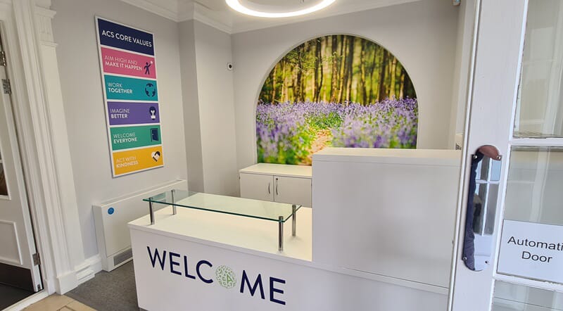 An image of a front desk with Welcome signage and directory.